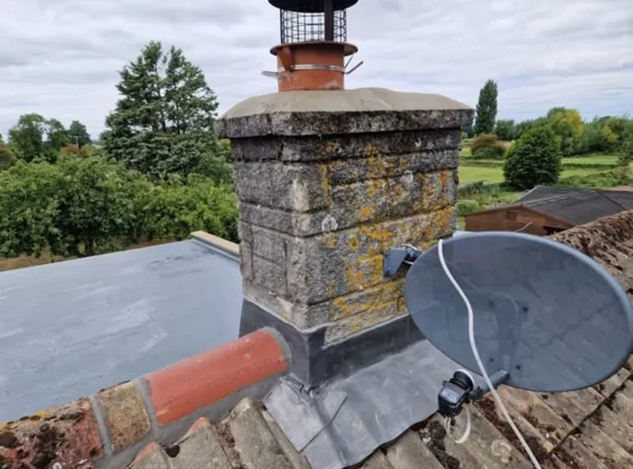 Lead flashing around the base of a stone chimney