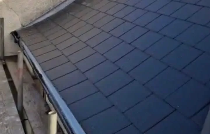 The eaves and guttering beneath a finished slate roof